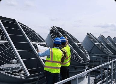 Engineers inspecting industrial cooling equipment